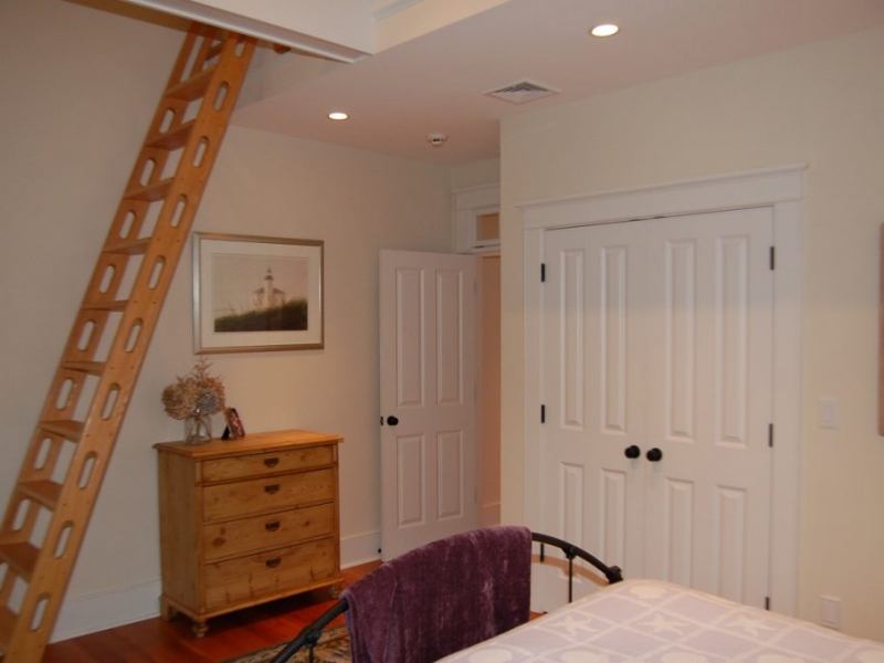 Bedroom with wooden ladder to loft