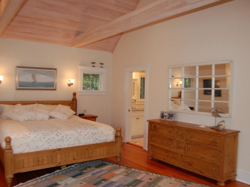 Bedroom with exposed wood celing and beams, hardwood floor